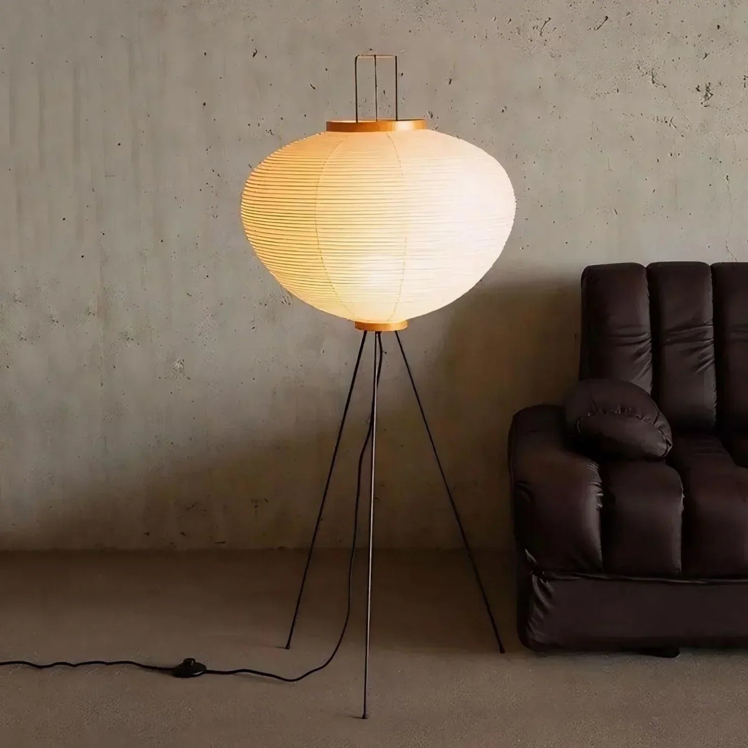 Luminária de chão com design moderno e sustentável, perfeita para sala de estar com sofá escuro e parede de concreto.